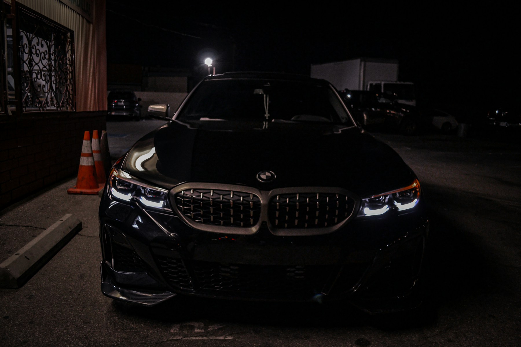 Crni BMW sa upaljenim svjetlima